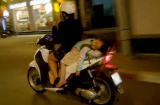 Mẹ lái xe bằng 1 tay mặc cho bé gái đang nằm dài sau yên xe ngủ