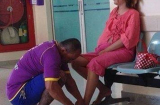 Anh chồng xăm trổ cắt móng chân cho vợ trước phòng khám thai