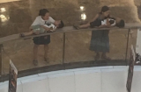 Hai bà mẹ trẻ hồn nhiên đặt con nhỏ đang ngủ say lên lan can tầng 2 trung tâm thương mại để nghỉ ngơi