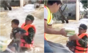 Trào nước mắt cảnh bé trai bơi giữa dòng nước lũ nhận đồ cứu trợ