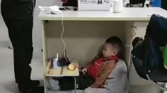 Đứa trẻ ngoan ngoãn ngồi dưới gầm bàn làm việc chật chội chờ mẹ tan làm khiến bao người xúc động