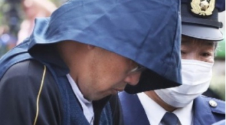 Nghi phạm s.át h.ại bé Nhật Linh xuất hiện trong chiếc khăn trùm đầu, mặt cúi gằm, tránh ống kính của phóng viên